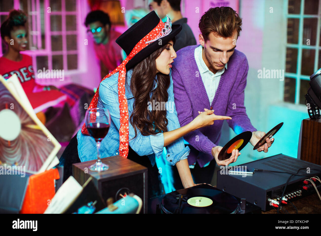 Couple playing records at party Banque D'Images Couple playing records at party Banque D'Images