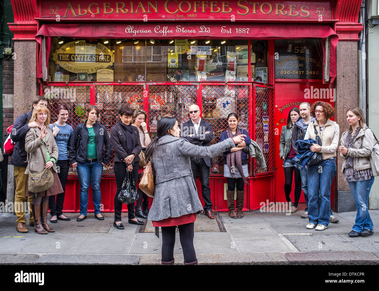 Un groupe de touristes en dehors des magasins de café algérien à Compton Street London UK Banque D'Images