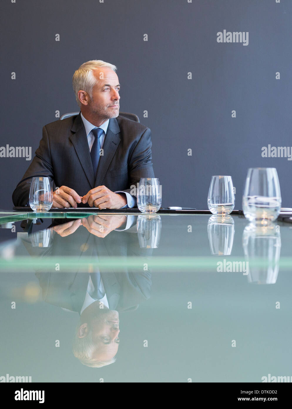 Businessman sitting at conference table Banque D'Images