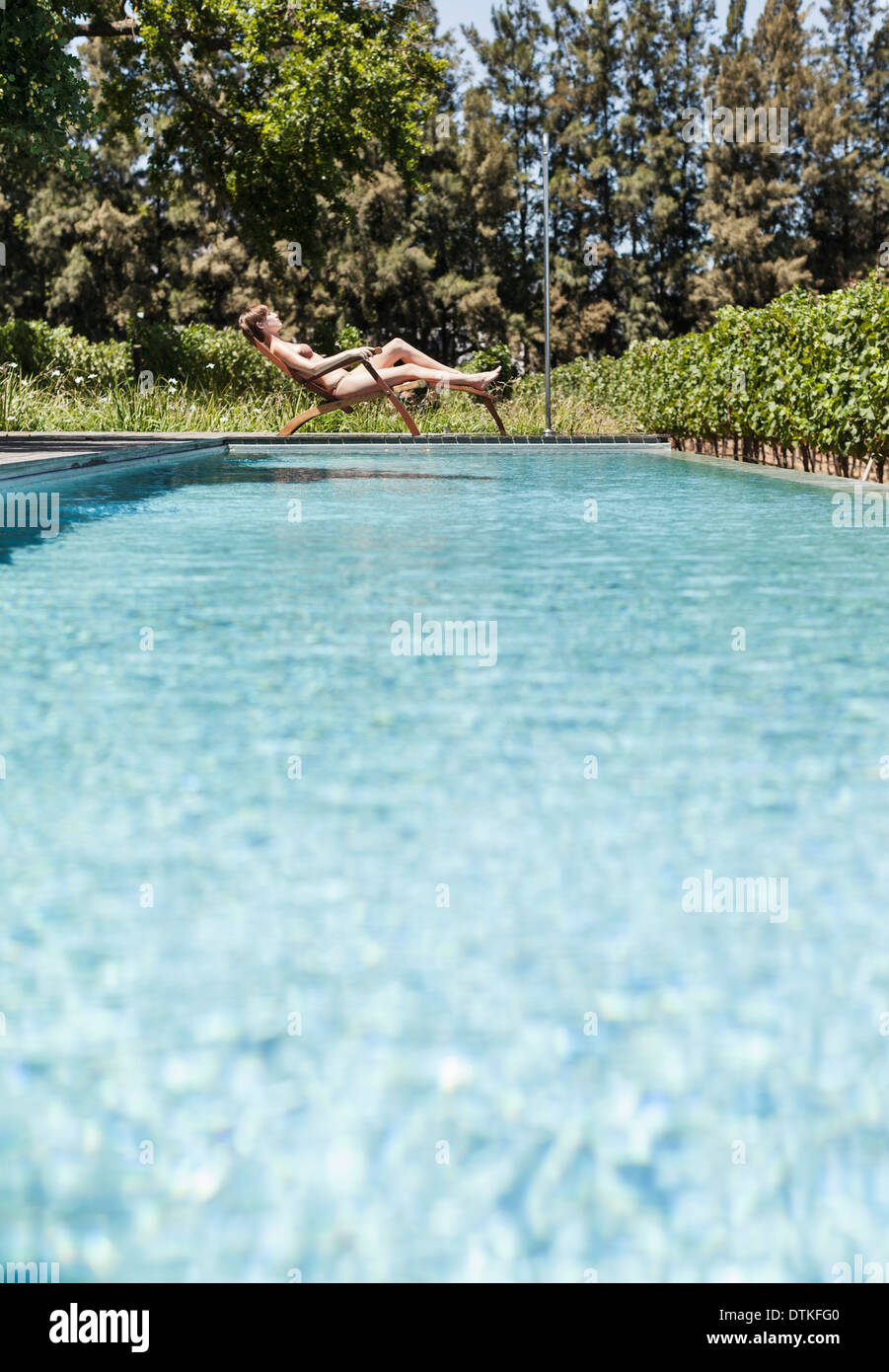 Woman relaxing by swimming pool Banque D'Images