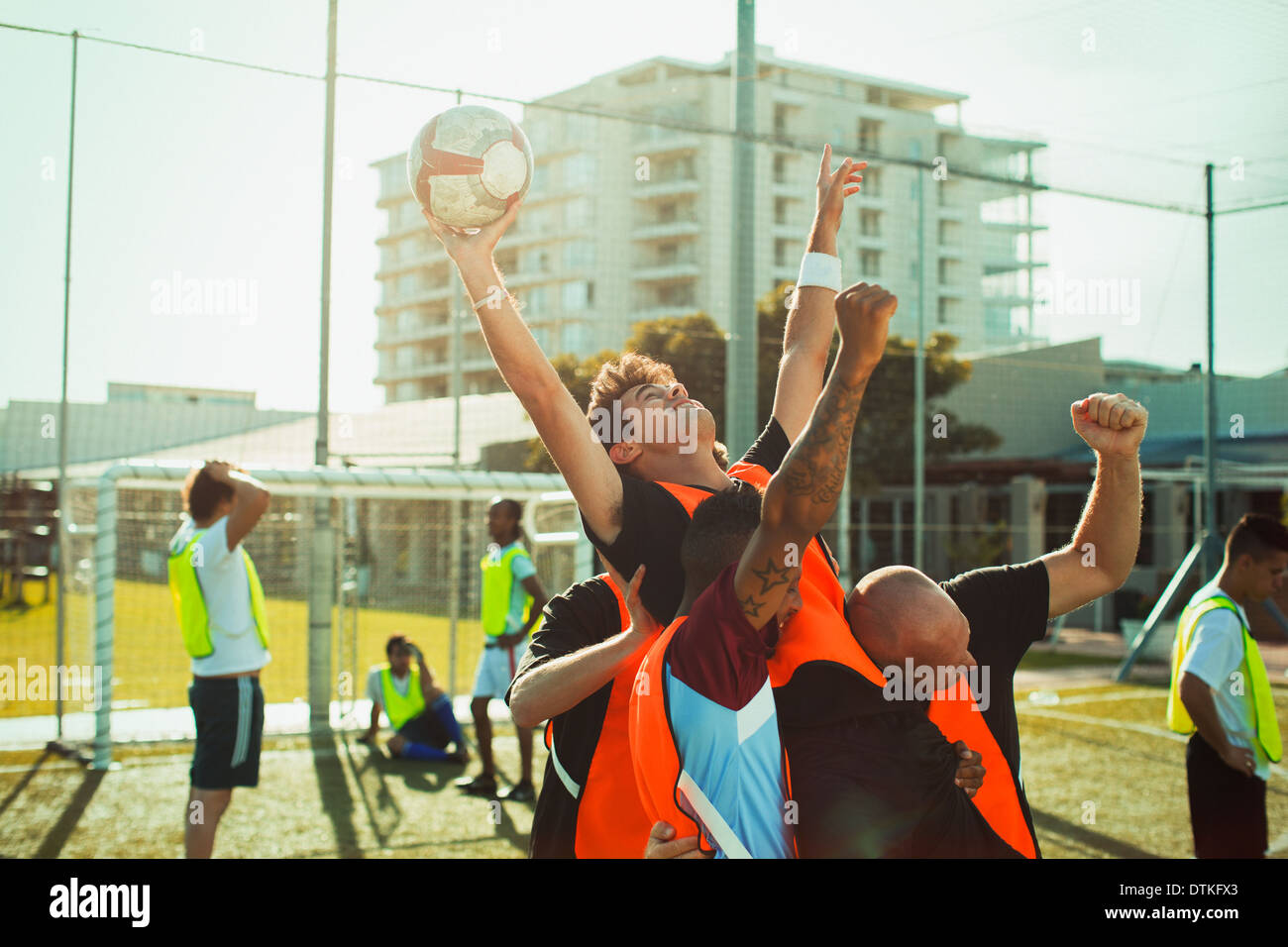 Joueurs de football cheering on field Banque D'Images