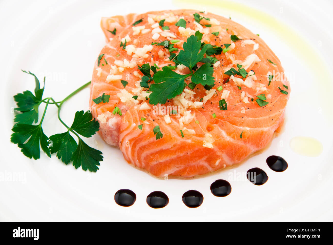 Filet de saumon mariné à l'huile d'olive, le persil, l'ail sur la plaque Banque D'Images