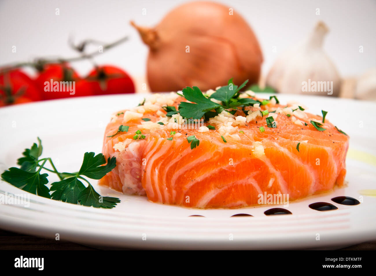 Filet de saumon mariné à l'huile d'olive, le persil, l'ail sur la plaque Banque D'Images