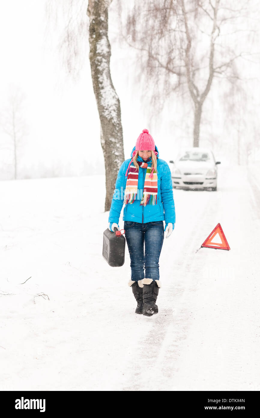 Femme transportant du gaz peut neige panne de voiture Banque D'Images