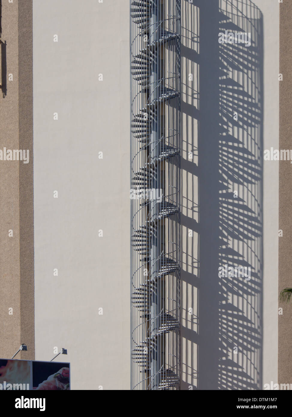 Escalier en spirale de sortie de secours et son ombre reflétée sur un immeuble situé à Playa Las Americas Tenerife Espagne Banque D'Images