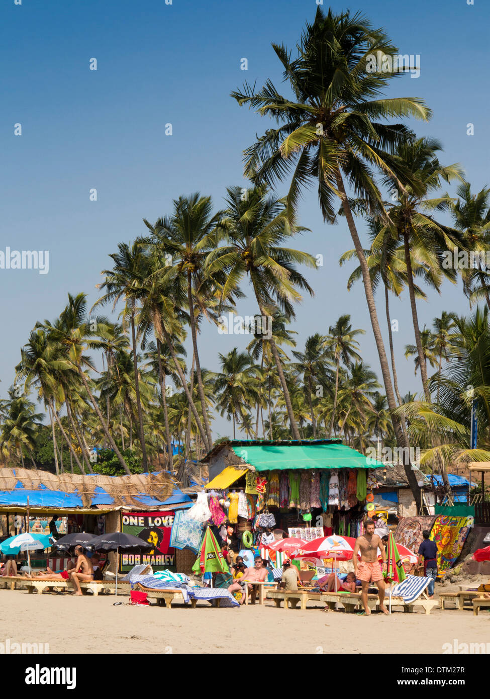 L'Inde, Goa, grande plage de Vagator, touriste russe sur les chaises longues au-dessous des barres de hauteur des cocotiers Banque D'Images