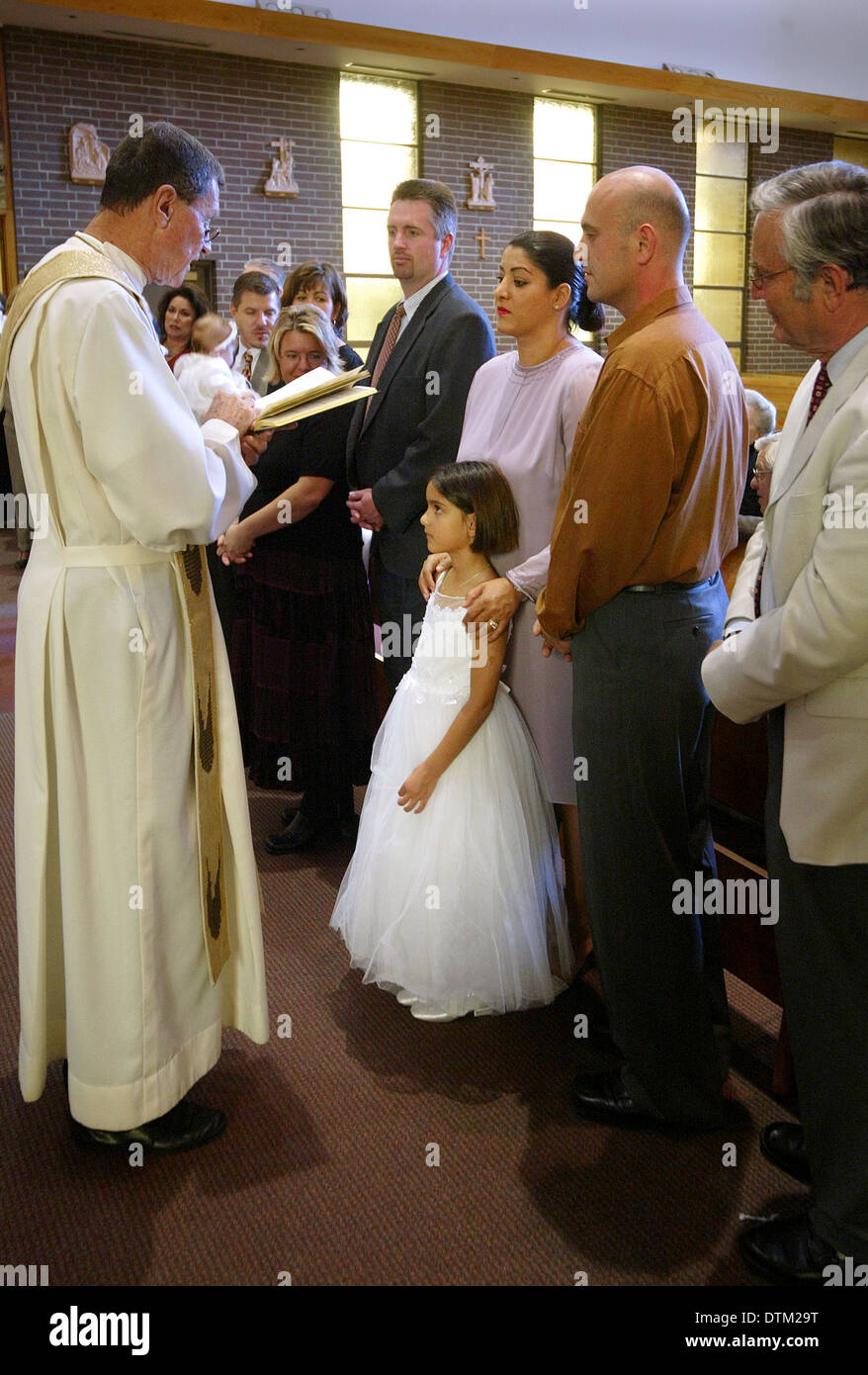 Un prêtre catholique robe lit un sermon pour les parents et les enfants au cours des cérémonies de baptême dans une église de Irvine, CA. Banque D'Images