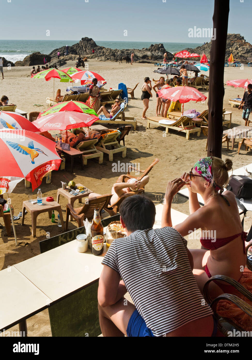 L'Inde, Goa, Anjuna Ozran, Fédération de couple drinking beer à l'ombre de beach shack bar Banque D'Images