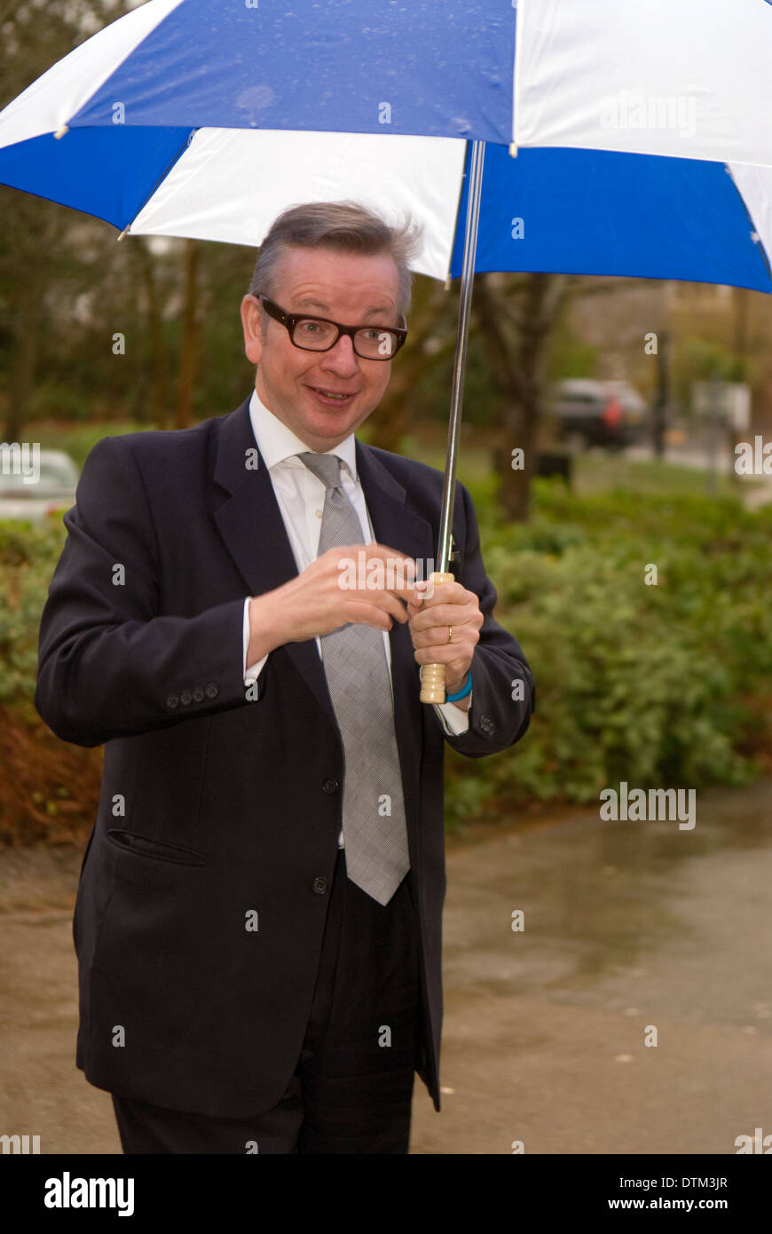 Secrétaire d'Etat à l'éducation, michael gove, arrivant sous la pluie pour une visite d'école, hindhead, Hampshire, Royaume-Uni. Banque D'Images