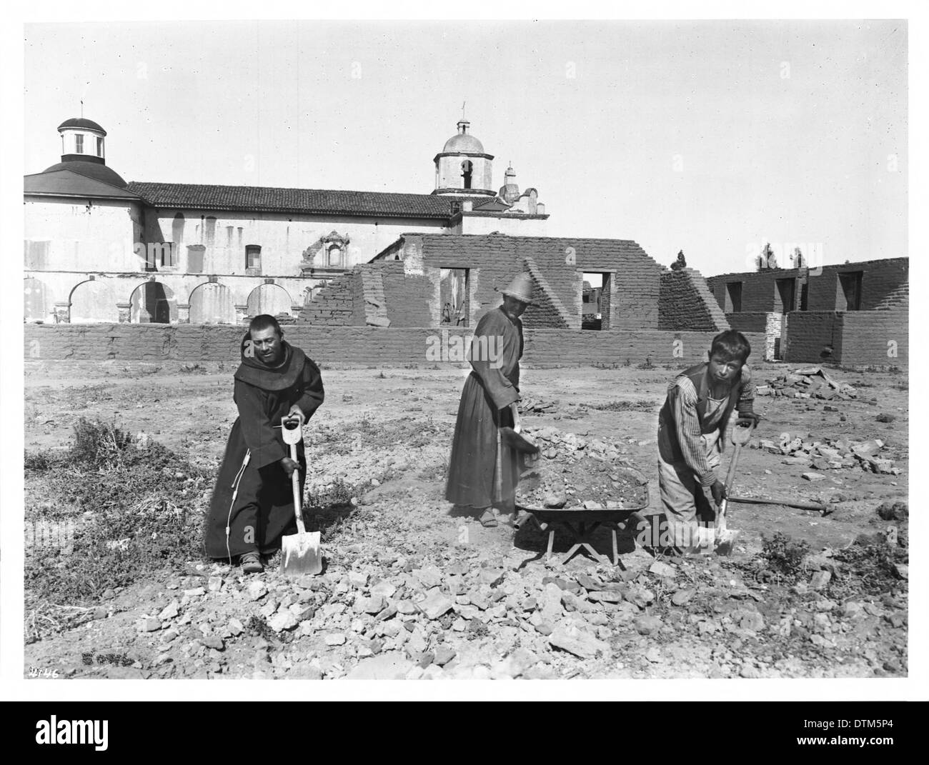 Deux néophytes et un garçon travaillent à la reconstruction de la Mission San Luis Rey de Francia, en Californie, capturée en 1904, montrant les premiers efforts de restauration. Banque D'Images