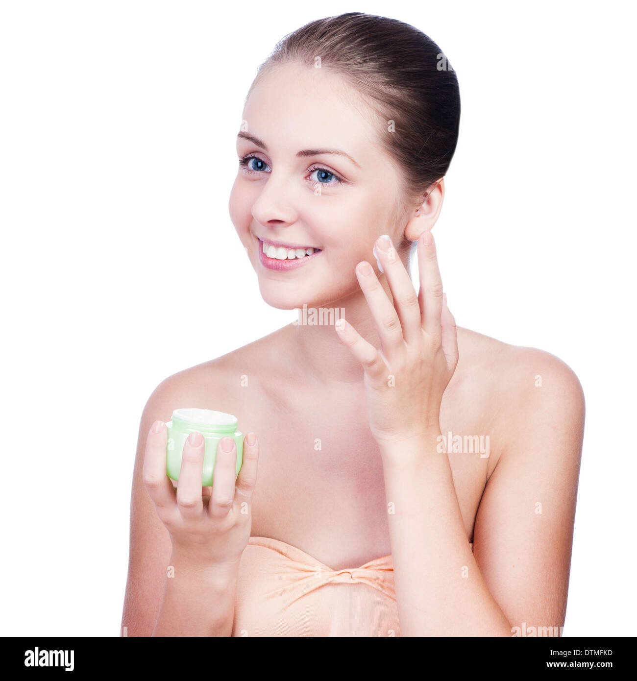 Close-up beau visage de jeune fille appliquant la crème hydratant - isolé Banque D'Images
