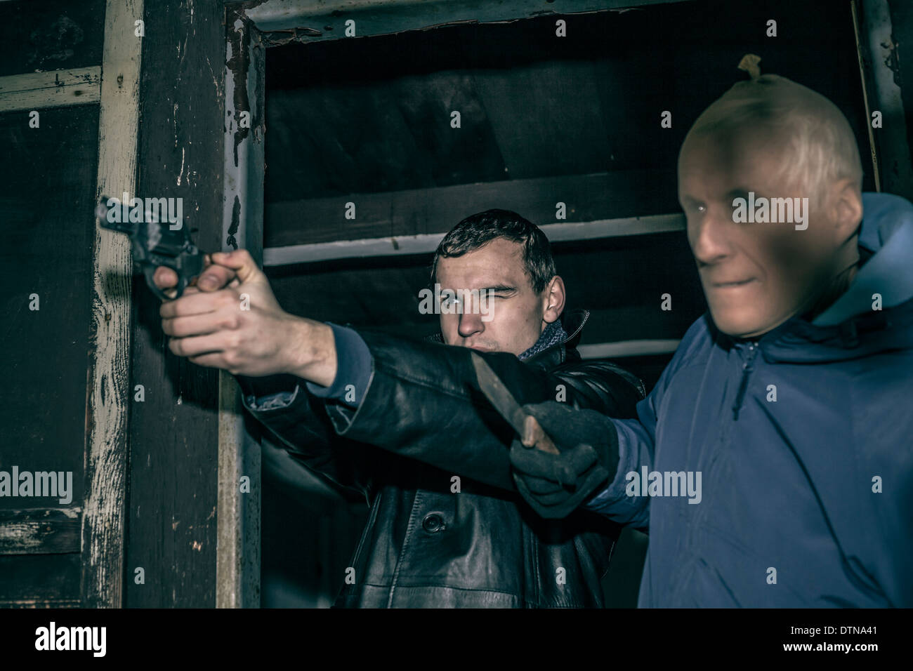 Deux hommes armés dangereux pointant avec des armes et de l'article dans la vieille cabine sombre. Banque D'Images