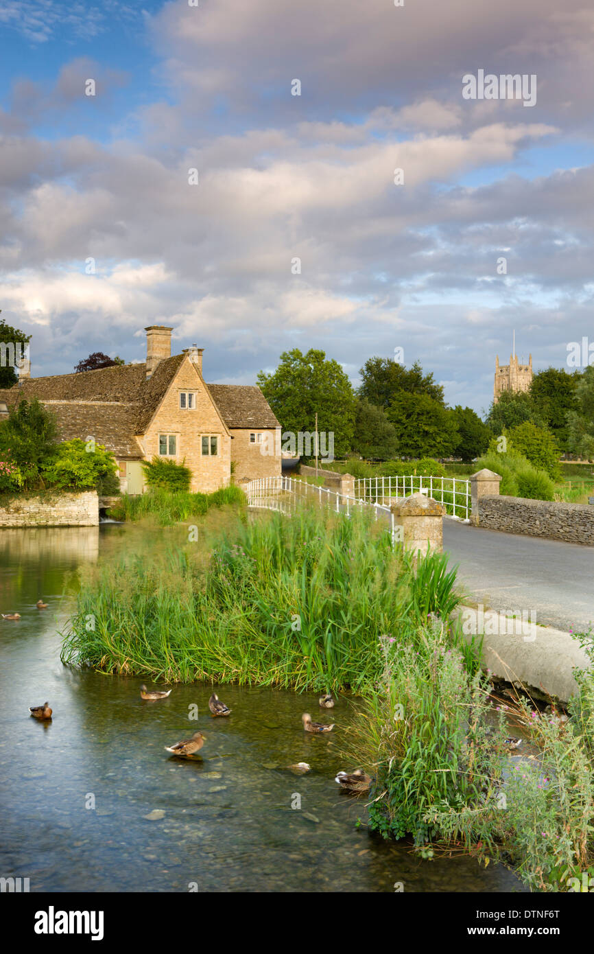 La lumière du soleil du soir s'allume sur l'ancien moulin et l'Eglise dans les Cotswolds village de Fairford, Gloucestershire, Angleterre. Banque D'Images