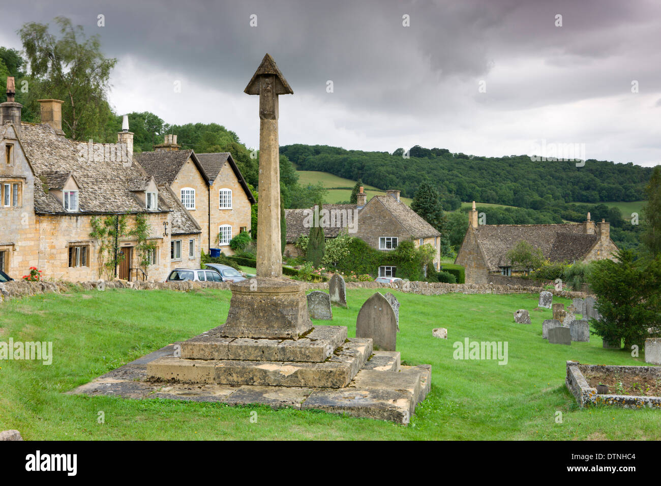 Cimetière de l'église St Barnabas et cottages dans le joli village de Cotswolds Snowshill, Worcestershire, Angleterre. Banque D'Images