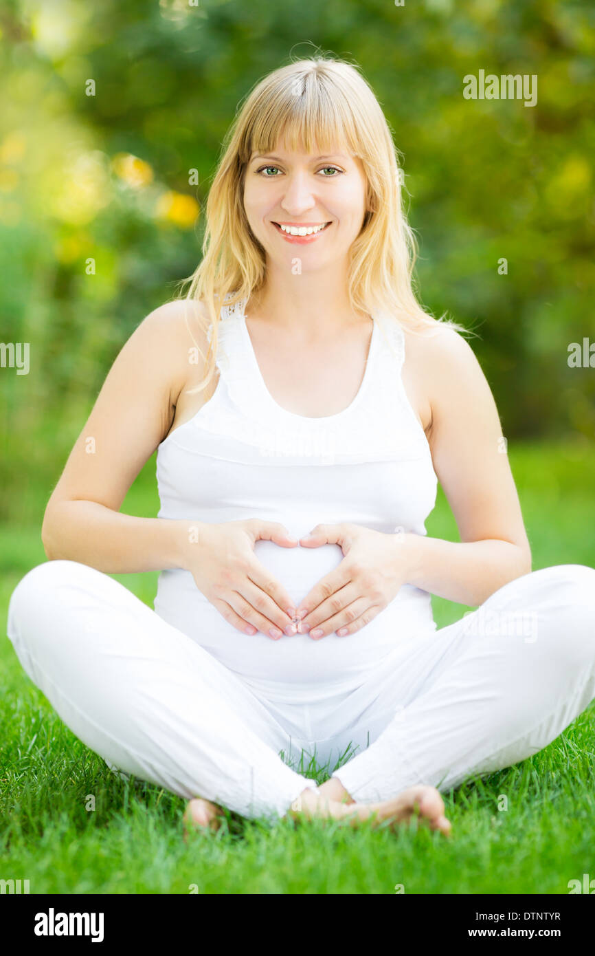 Pregnant woman holding hands on belly Banque D'Images