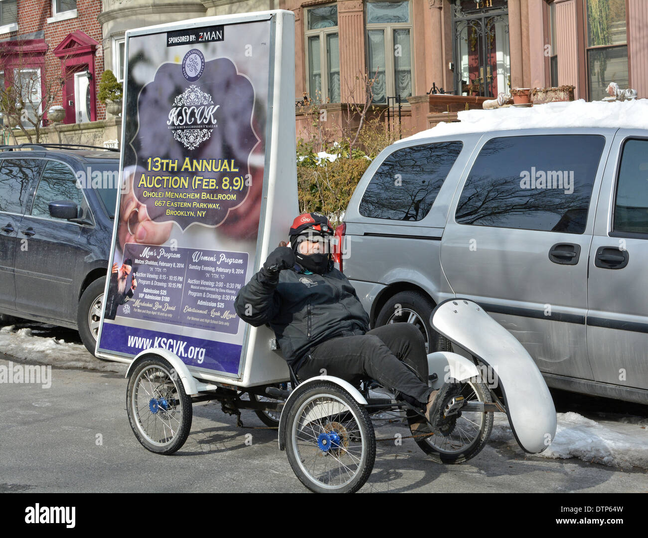 Un homme sur un vélo à quatre roues de la publicité pour une vente de charité Crown Heights à Brooklyn, New York Banque D'Images