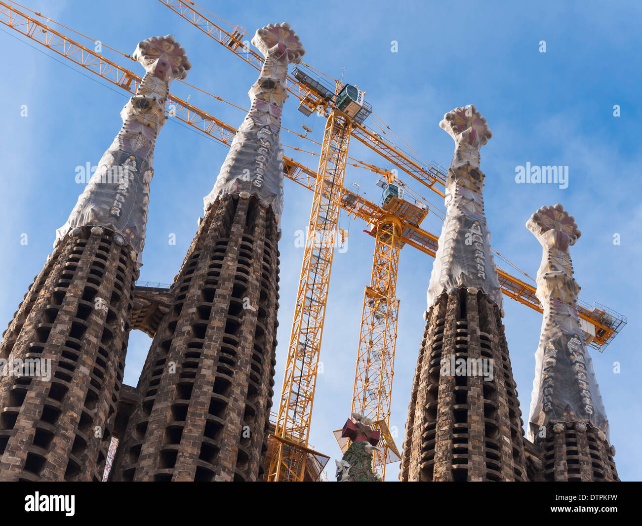 Grues de construction à la façade de la nativité "tours" d'Antonio Gaudi's cathédrale "Sagrada Familia" à Barcelone, Espagne. Banque D'Images