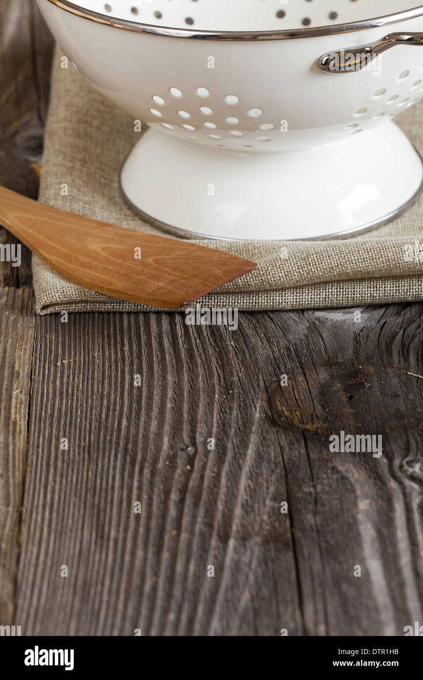 Passoire émail et une cuillère de cuisine se tient sur la table de cuisine exemplaire de l'espace dans la zone inférieure de l'image Banque D'Images