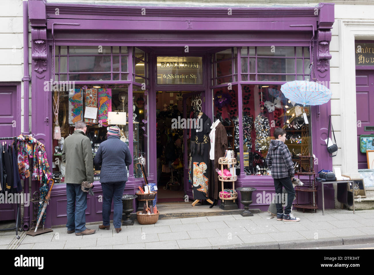 Les personnes à la recherche d'antiquités dans une boutique de curiosités et d'élégants vêtements sur des mannequins couturiers Banque D'Images