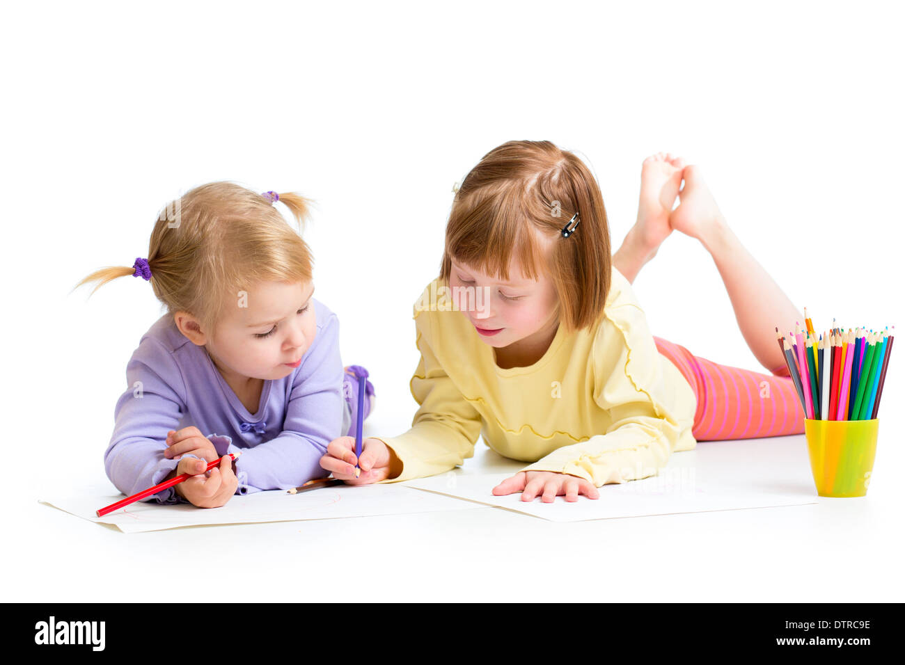 Deux filles dessin avec des crayons de couleurs ensemble over white Banque D'Images