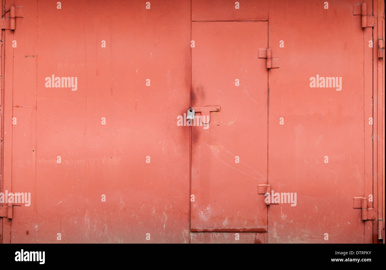 Garage métal rouge mur avec portail fermé. La texture d'arrière-plan Banque D'Images