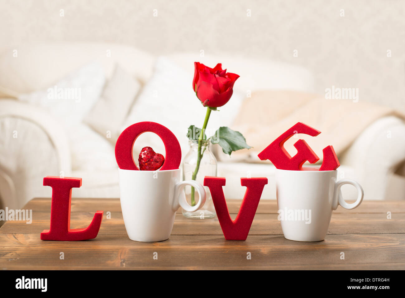 L'amour des lettres rouges dans les tasses avec rose rouge dans un vase pour la Saint-Valentin Banque D'Images