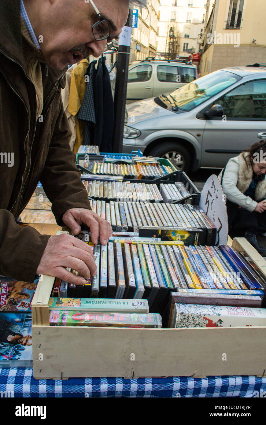 Paris, France., l'homme Français Shopping Brocante dans région de Belleville, à la recherche des films DVD, vendeur de rue, le choix de l'acheteur des marchandises Banque D'Images