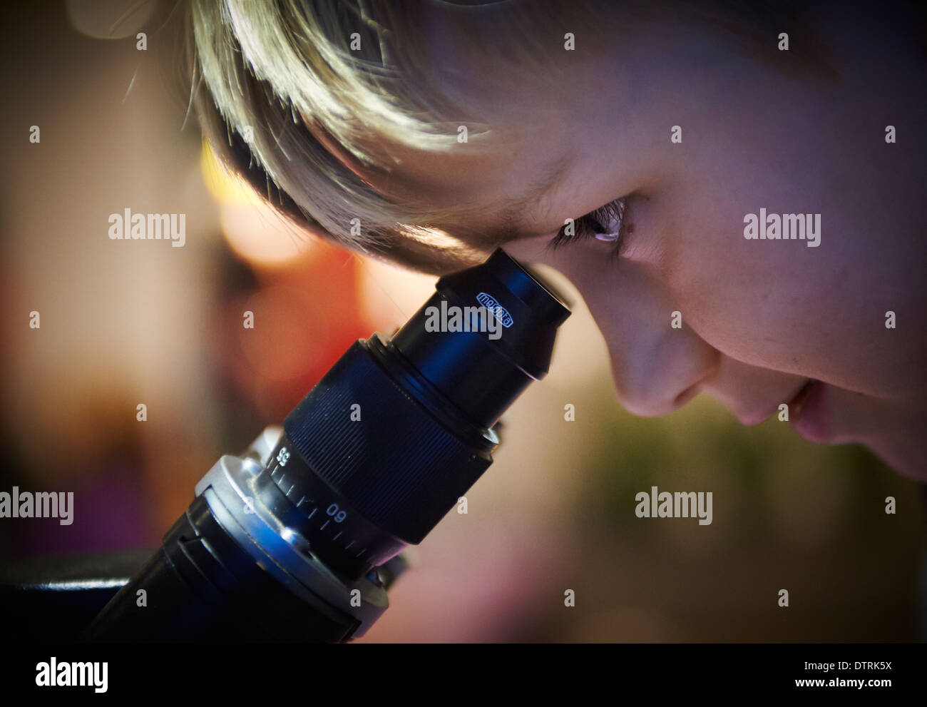 Portrait d'enfant Boy looking through microscope dans laboratoire d'école Banque D'Images