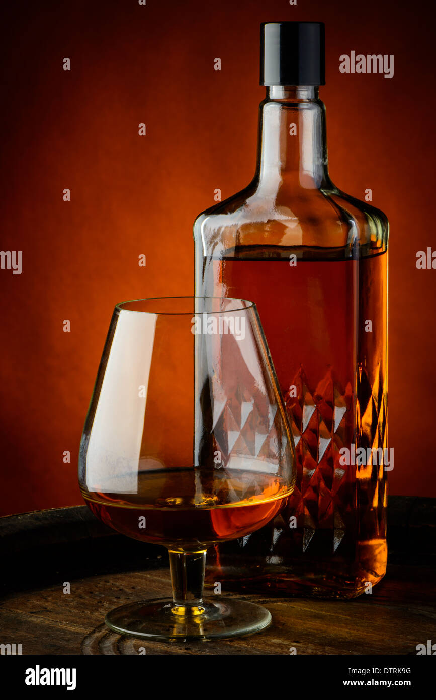 Nature morte avec verre et la bouteille de cognac sur un tonneau en bois Banque D'Images