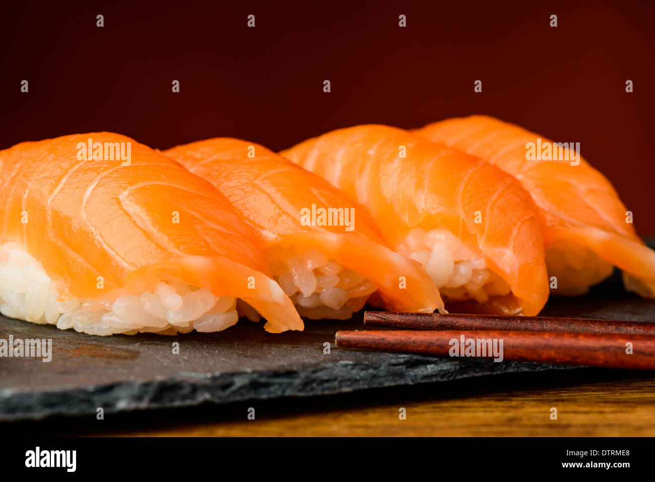 Closeup détail de nigiri sushi au saumon et baguettes Banque D'Images