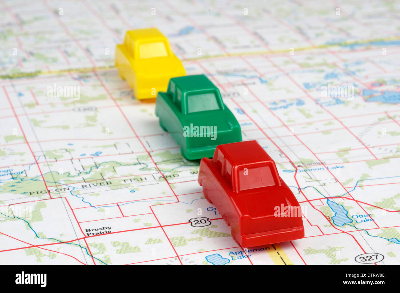 Rouge,jaune,vert voitures miniatures sont le déplacement en marche avant sur une carte. Banque D'Images