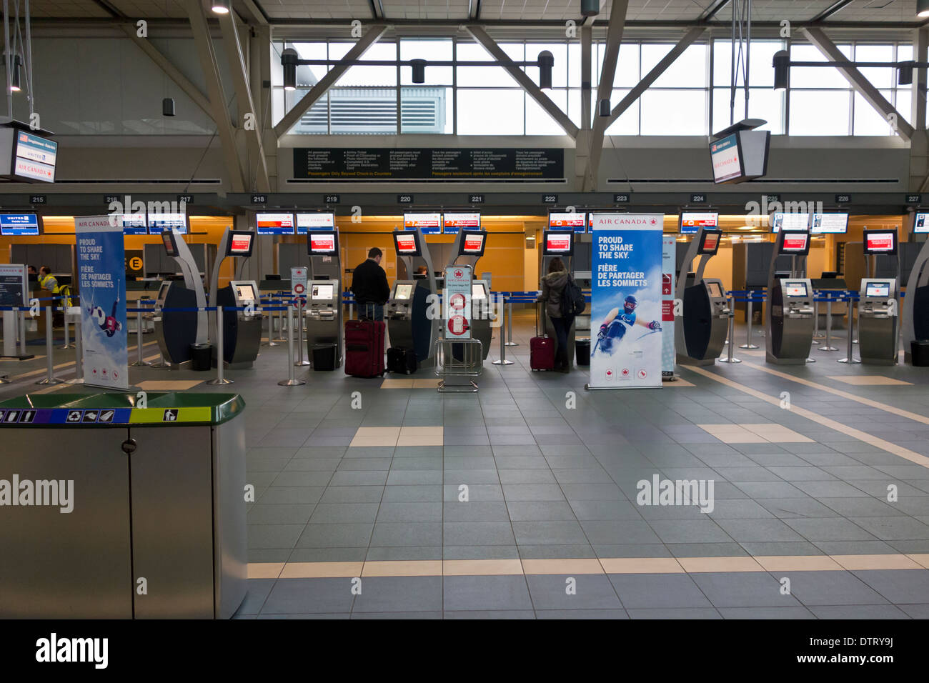 Les passagers avec bagages en utilisant les bornes d'enregistrement d'Air Canada dans le volet international de l'Aéroport International de Vancouver YVR. Banque D'Images