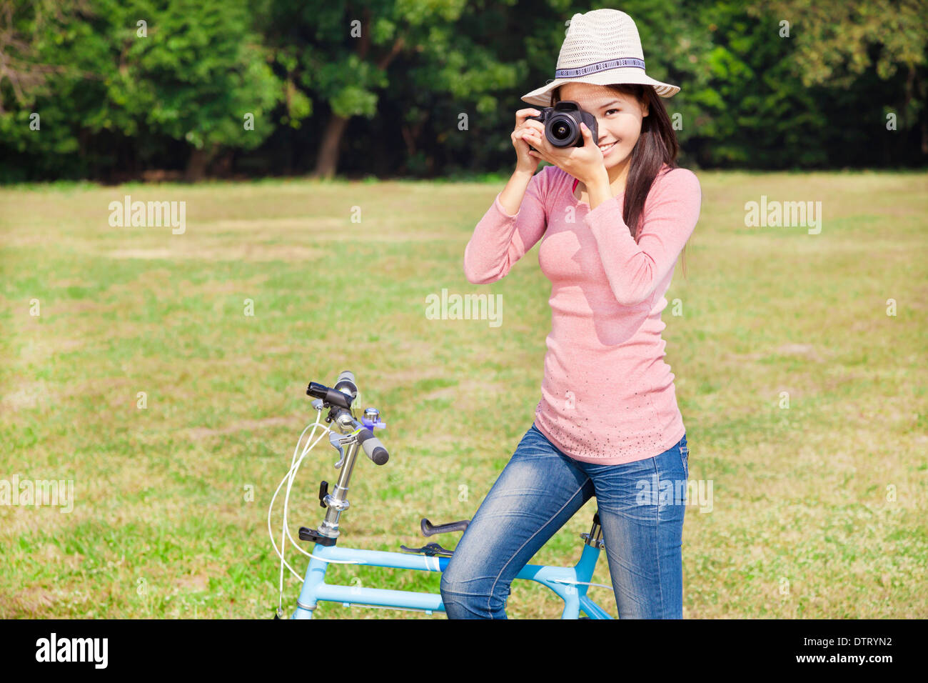 Femme photographe holding camera et vélo assis Banque D'Images