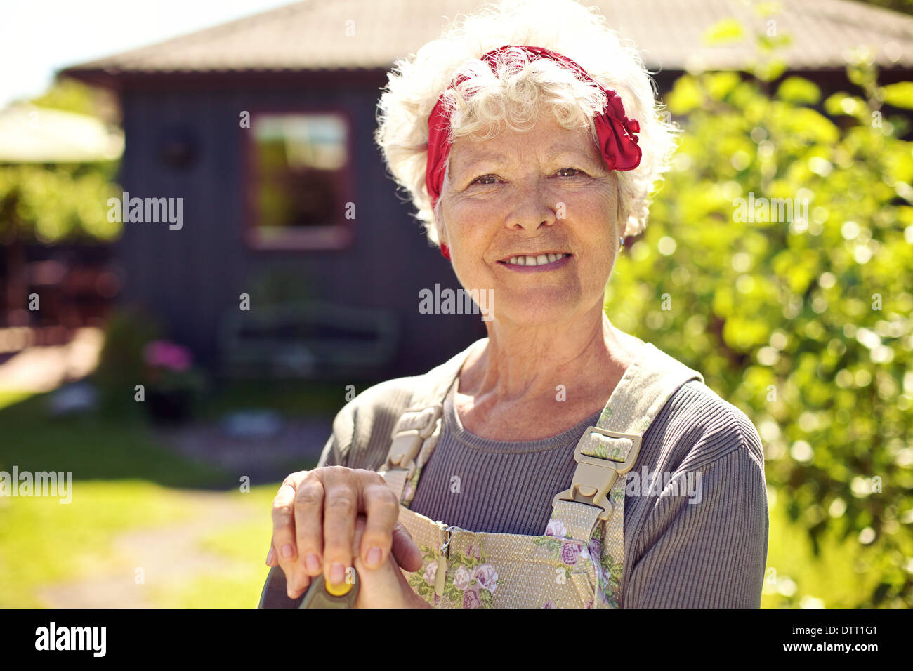 Closeup portrait of senior woman standing in backyard garden Banque D'Images