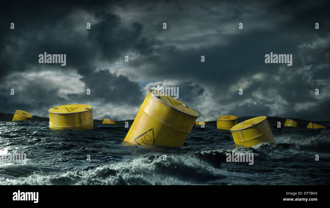 Barils de pétrole flottant dans la mer orageuse Banque D'Images