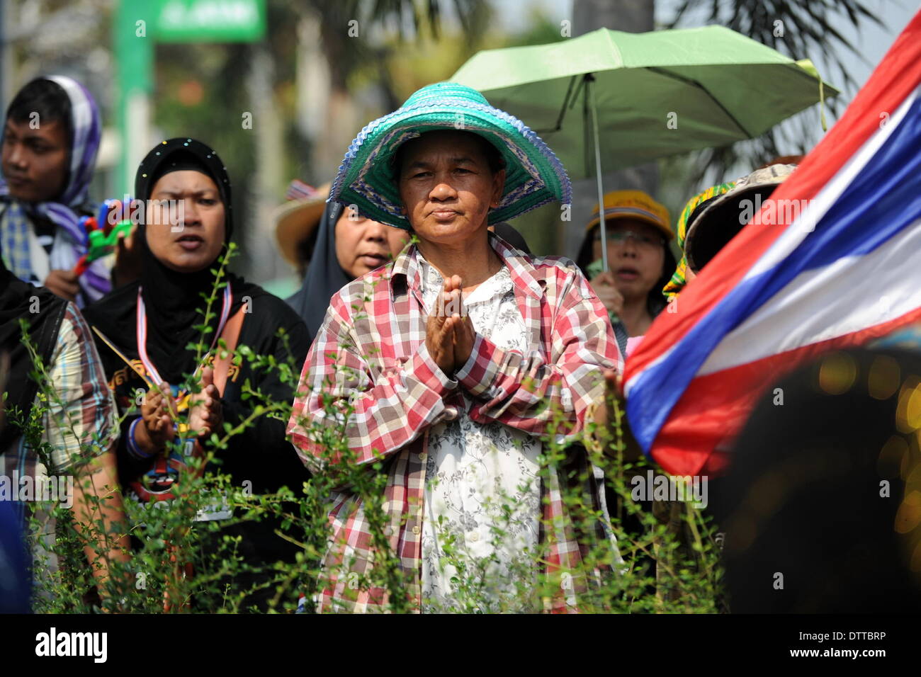 Bangkok, Thaïlande. Feb 24, 2014. Un manifestant anti-gouvernement prie à la porte avant d'un bâtiment appartenant à la voix de la Thaïlande PLAT Corp pendant un rassemblement à Bangkok, Thaïlande, le 24 février 2014. Des manifestants anti-gouvernement essayant d'évincer le gouvernement de Yingluck Shinawatra le lundi se sont rassemblées devant plusieurs entreprises considérées comme les entreprises de la famille Shinawatra. Credit : Gao Jianjun/Xinhua/Alamy Live News Banque D'Images