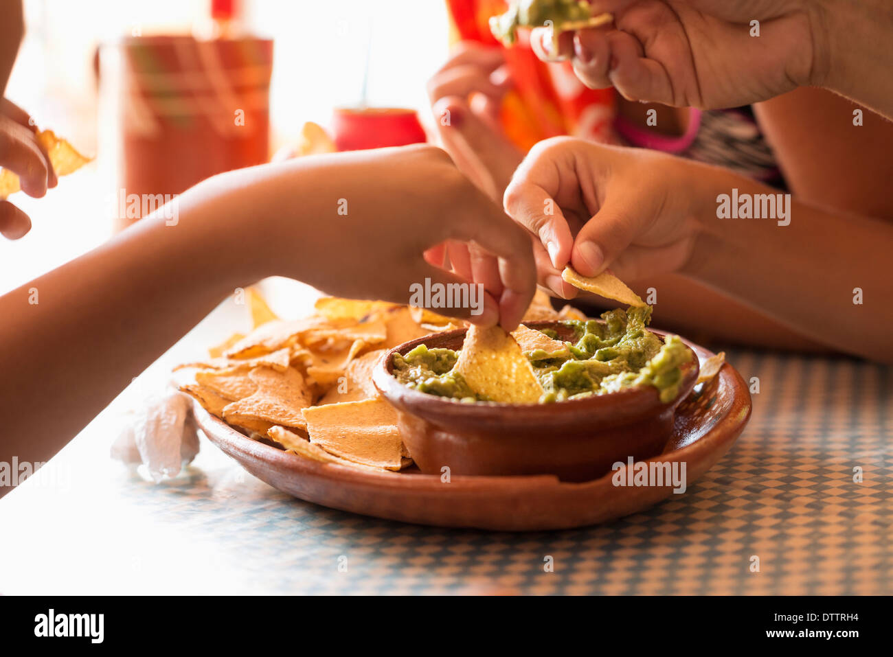 Les enfants de manger des frites et guacamole Banque D'Images