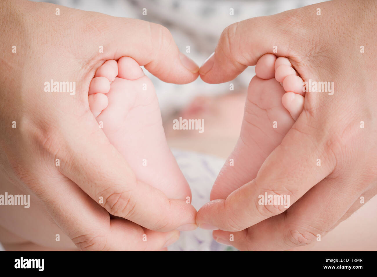Close up of Hispanic mother cupping Baby Boy's feet Banque D'Images