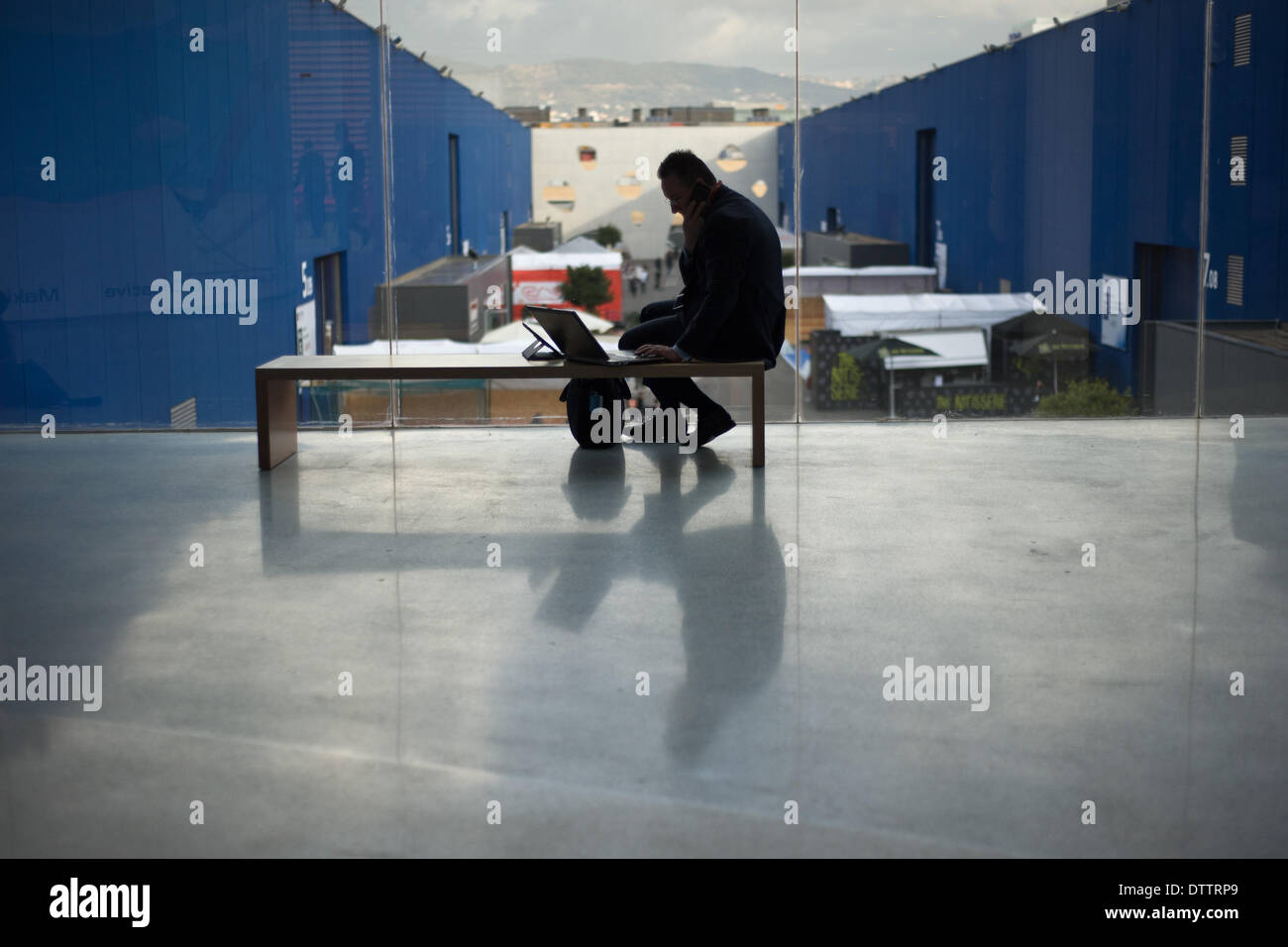 L'Hospitalet (Barcelone), Espagne - 24 Février, 2014. Un homme travaille sur son portable au MWC. Le Mobile World Congress 2014 ouvre ses portes avec une fréquentation de 75 000 visiteurs attendus. Crédit : Jordi Boixareu/Alamy Live News Banque D'Images