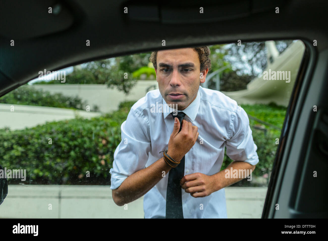 Hispanic businessman contrôler sa cravate dans le rétroviseur de voiture  Photo Stock - Alamy