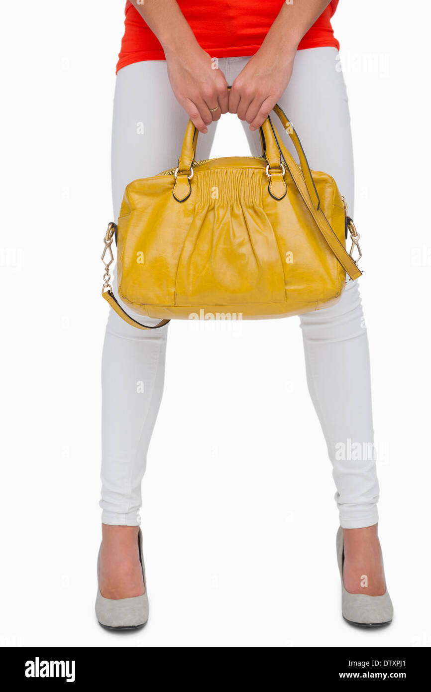 Femme en blanc leggings holding sac jaune Banque D'Images