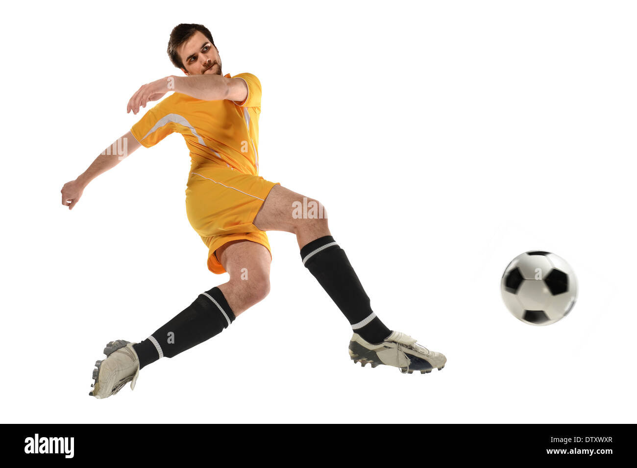 Soccer player kicking ball dans l'air isolé sur fond blanc Banque D'Images