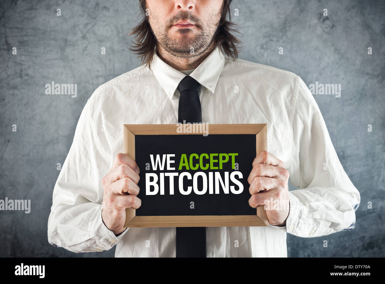 Businessman holding board avec le titre Nous acceptons des BITCOINS comme forme de paiement. Banque D'Images