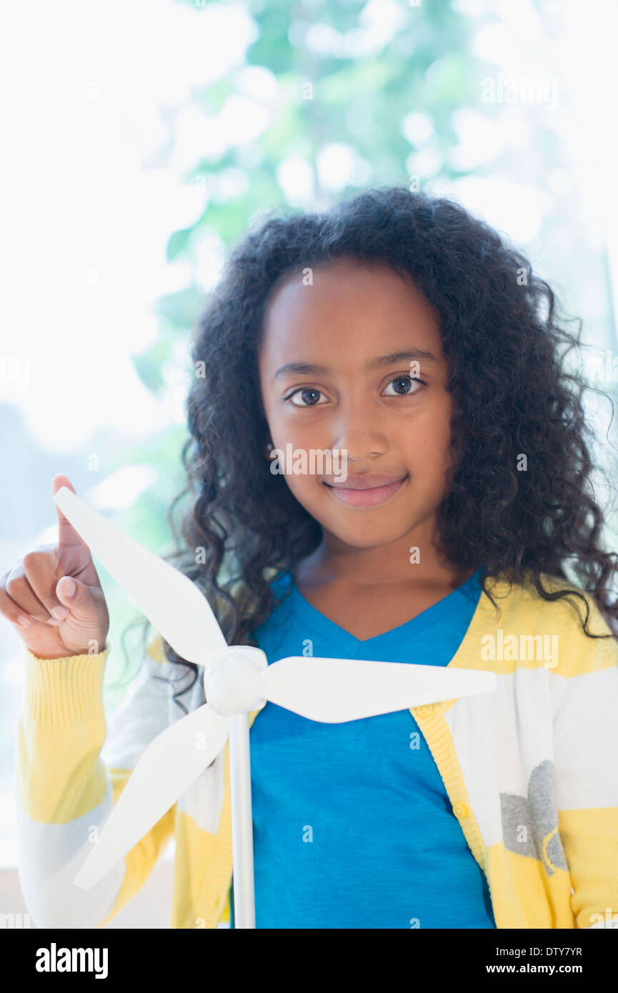 Mixed Race girl with model wind turbine Banque D'Images