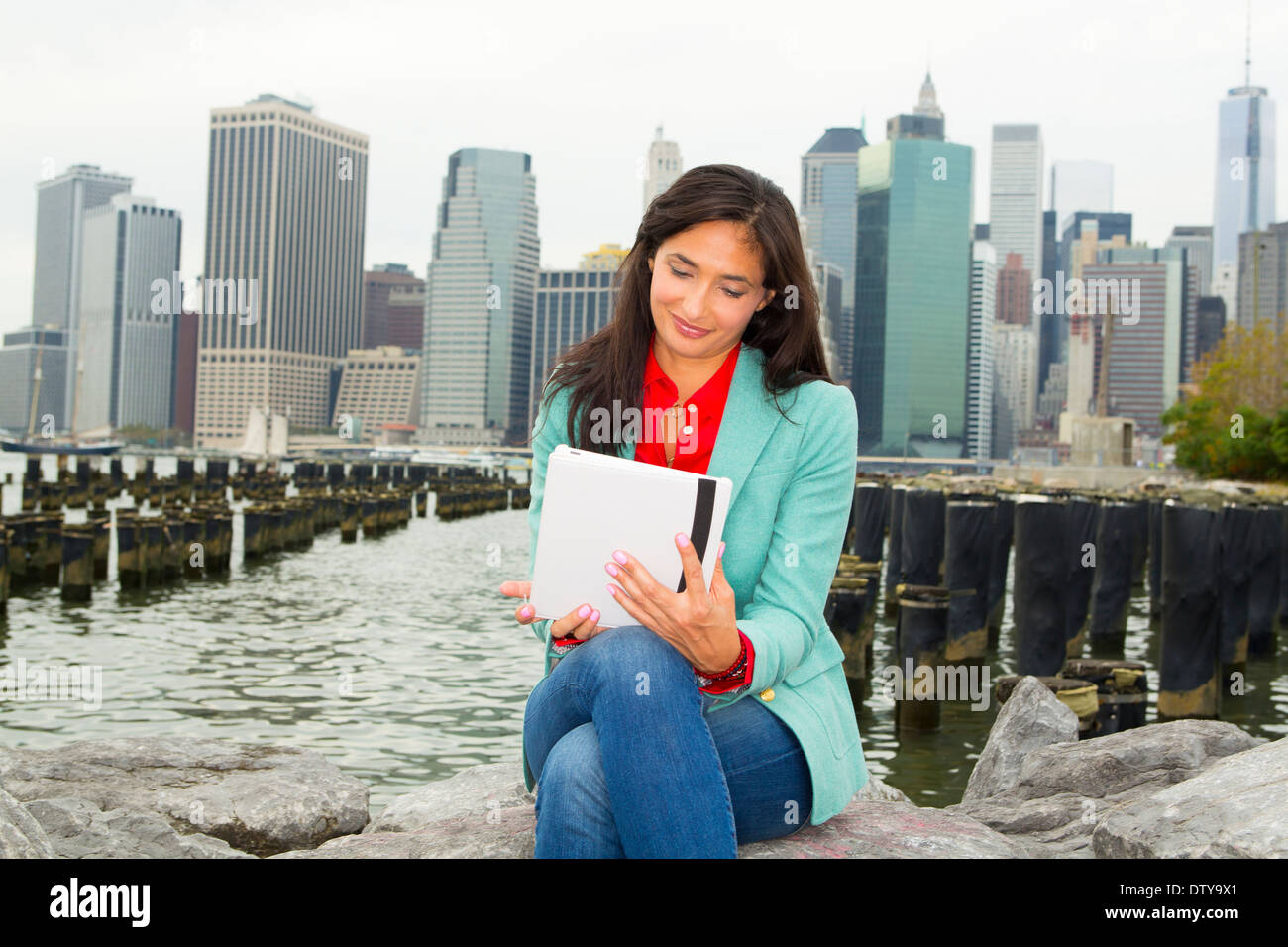 Mixed Race woman using digital tablet at waterfront, New York, New York, United States Banque D'Images