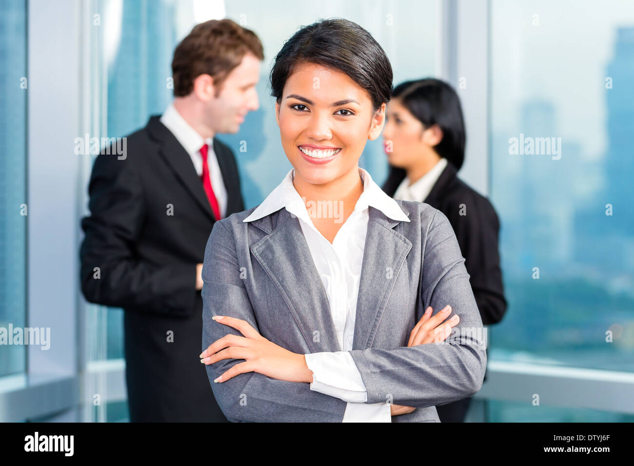 L'équipe entreprises asiatiques dans office, la femme à l'avant avec skyline Banque D'Images