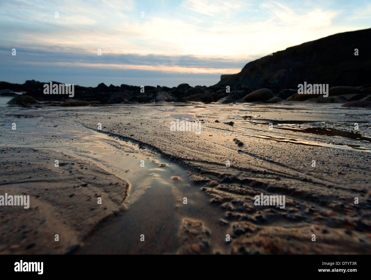 Lumière dorée dans les patterns dans le sable à Saltwick Bay Whitby, North Yorkshire Angleterre UK Banque D'Images