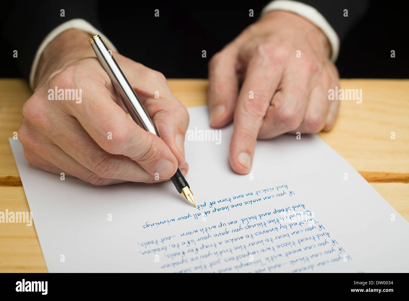 Un homme d'écrire avec un stylo sur un papier blanc fixé sur un pont boisé Banque D'Images
