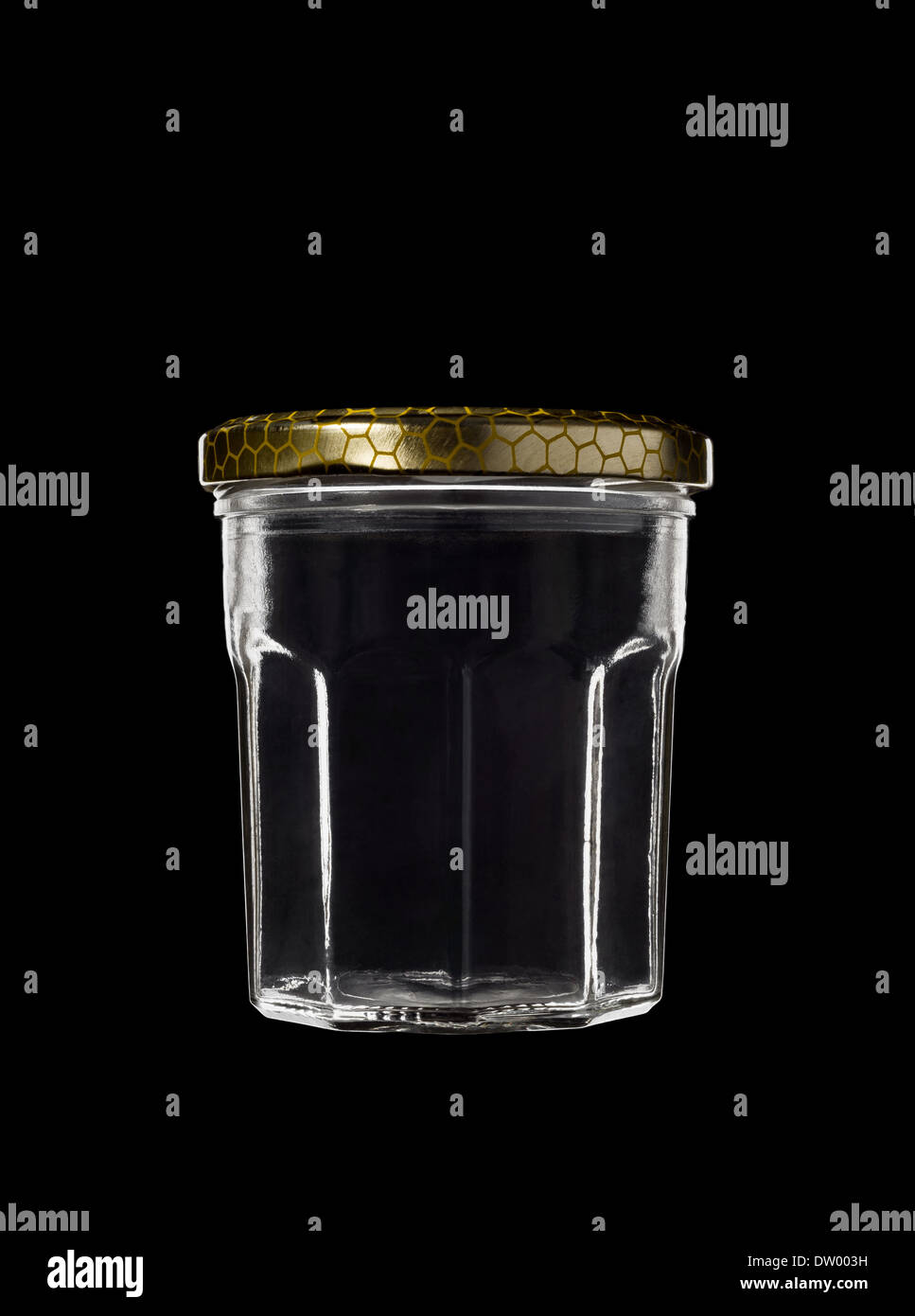 Pot en verre transparent sur fond noir, avec le haut en couleur or fermé Banque D'Images