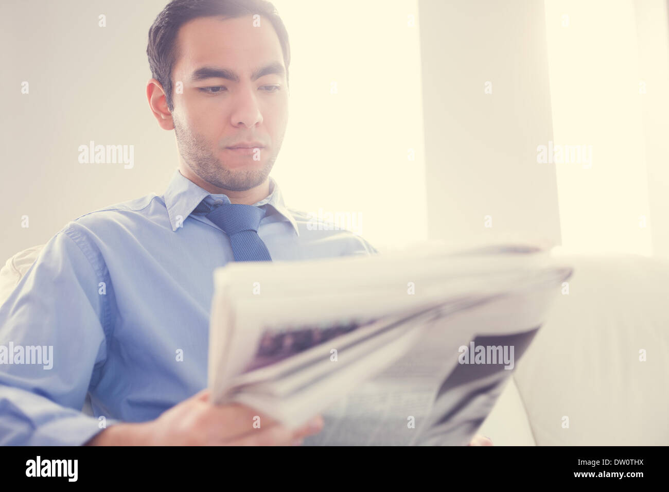 De graves handsome businessman reading newspaper Banque D'Images